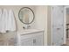 Cozy half-bathroom featuring white vanity, decorative mirror, and convenient towel hooks at 4152 Winding Pines Dr, Apopka, FL 32712