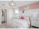 This is a stylish bedroom with pink accent wall, heart mirrors, and floral comforter at 4152 Winding Pines Dr, Apopka, FL 32712
