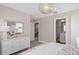 This bedroom is bright and airy, featuring a decorative chandelier, dresser, and ensuite bathroom at 4152 Winding Pines Dr, Apopka, FL 32712