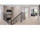 Upstairs hallway with decorative railing, carpeted floor, and views into a sitting room and downstairs living area at 4152 Winding Pines Dr, Apopka, FL 32712