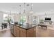 Bright, open kitchen with a center island, modern lighting and appliances, and a seamless flow to the living area at 4152 Winding Pines Dr, Apopka, FL 32712