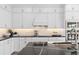 Gourmet kitchen with black countertops, white cabinets, and a designer backsplash at 4152 Winding Pines Dr, Apopka, FL 32712