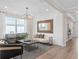 Bright and airy living room featuring contemporary furniture, a modern mirror, and wood look tile flooring at 4152 Winding Pines Dr, Apopka, FL 32712