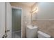 Bathroom with tiled walls, a vanity sink and an open doorway at 4748 Amoy Ct, Orlando, FL 32811
