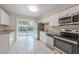 Modern kitchen featuring stainless steel appliances, white cabinets, and ample counter space for meal preparation at 4748 Amoy Ct, Orlando, FL 32811