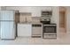 Galley kitchen featuring stainless steel appliances, granite countertops, and white cabinetry at 4748 Amoy Ct, Orlando, FL 32811