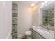 A bathroom showing grey granite vanity and shower with wood-style tile surround at 4805 Okeefe St, Orlando, FL 32808