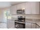 Kitchen with stainless steel appliances, stone countertops, and gray cabinets at 4805 Okeefe St, Orlando, FL 32808