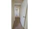 Hallway with neutral paint and carpet flooring and an open door at 502 Eagle Ct, Kissimmee, FL 34759