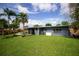 Back of home showcasing sliding glass doors, privacy fence, and spacious lawn at 5384 Barton Dr, Orlando, FL 32807