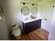 Bathroom featuring a double sink vanity, modern fixtures, wood-look floors, and neutral walls at 5384 Barton Dr, Orlando, FL 32807