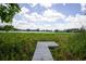 Wooden dock leading to a picturesque lake surrounded by lush greenery at 5384 Barton Dr, Orlando, FL 32807