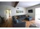 Living room featuring wood floors, exposed beams, and comfortable gray sectional at 5384 Barton Dr, Orlando, FL 32807