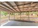 Covered back porch with concrete floor and wooden railing overlooking backyard at 5500 Riviera Dr, Orlando, FL 32808