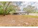 Home exterior showcasing a spacious backyard with mature trees at 5500 Riviera Dr, Orlando, FL 32808