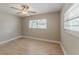 Bright bedroom featuring light hardwood floors and two windows bringing in natural light at 5500 Riviera Dr, Orlando, FL 32808