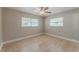 Bright bedroom featuring a ceiling fan, light hardwood floors and two windows bringing in natural light at 5500 Riviera Dr, Orlando, FL 32808