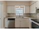 Close-up of kitchen with white cabinets, stainless appliances, and decorative backsplash at 5500 Riviera Dr, Orlando, FL 32808