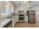 Updated kitchen with stainless steel appliances, stylish backsplash, and ample cabinet space at 5500 Riviera Dr, Orlando, FL 32808