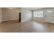 Open living space featuring updated vinyl flooring and neutral paint with a view of the front door and window at 5500 Riviera Dr, Orlando, FL 32808