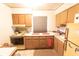 Functional kitchen with wood cabinetry, laminate countertops, and essential appliances for cooking at 5505 Hernandes Dr # 108, Orlando, FL 32808