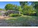 A view of the home's fenced backyard shows a pool enclosure and surrounding greenery at 5709 Breskin Dr, Orlando, FL 32839
