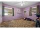 Bedroom with a ceiling fan and two windows letting in natural light, a brown carpet, and purple walls at 5709 Breskin Dr, Orlando, FL 32839
