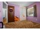 Bedroom featuring purple walls, brown carpet, and a closet; a doorway can be seen on the left at 5709 Breskin Dr, Orlando, FL 32839