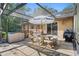 Outdoor living space showcasing a screened-in pool area with a table and chairs under a sun umbrella at 5709 Breskin Dr, Orlando, FL 32839