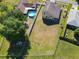 Aerial shot of the backyard with a pool, fencing, green grass, and a view of nearby homes at 602 Milan Dr, Kissimmee, FL 34758