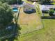Aerial view of a fully fenced, expansive backyard with green grass, an above ground pool, and the home at 602 Milan Dr, Kissimmee, FL 34758