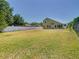 Large backyard with a green lawn, a white vinyl fence, and a view of the home at 602 Milan Dr, Kissimmee, FL 34758