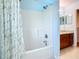 Well-lit bathroom featuring a shower-tub combo, neutral colored walls, and a granite vanity top at 602 Milan Dr, Kissimmee, FL 34758