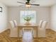 This dining area features a ceiling fan, a large window with a view, white walls, and a decorative tile floor at 602 Milan Dr, Kissimmee, FL 34758