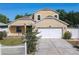 This home features an attached two-car garage, neutral paint, and an manicured front yard with a white picket fence at 602 Milan Dr, Kissimmee, FL 34758