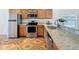 This kitchen features wooden cabinets, granite countertops, stainless steel appliances, and a decorative tile floor at 602 Milan Dr, Kissimmee, FL 34758
