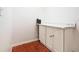 A small room with a cabinet, a countertop, and brown tiled floors at 602 Milan Dr, Kissimmee, FL 34758