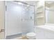 Clean bathroom with glass enclosed shower, grey floor tile, white walls and floating white shelves at 7484 Canford Ct # 8, Winter Park, FL 32792