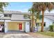 Charming townhome featuring a vibrant red front door, carport, and mature palm trees enhancing curb appeal at 7484 Canford Ct # 8, Winter Park, FL 32792