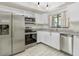 Modern kitchen with stainless steel appliances, white cabinets, and granite countertops at 7484 Canford Ct # 8, Winter Park, FL 32792