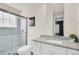Modern bathroom featuring white vanity, granite countertop, and glass-enclosed shower, showcasing clean design at 7587 Sunflower Cir, Kissimmee, FL 34747