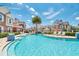 Gorgeous community pool surrounded by colorful townhomes and lounge chairs, perfect for summer relaxation at 7587 Sunflower Cir, Kissimmee, FL 34747