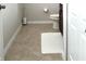 Powder room with a chocolate-colored vanity, tiled floor, toilet, and a white bathmat on the tile flooring at 7675 Fordson Ln, Windermere, FL 34786