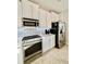 Close up of the kitchen featuring modern appliances, white cabinets, and sleek countertops at 7675 Fordson Ln, Windermere, FL 34786