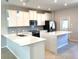 Bright kitchen featuring white cabinets, stone countertops, and stainless steel appliances at 7675 Fordson Ln, Windermere, FL 34786