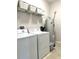 Bright laundry room with washer, dryer, shelving, decor baskets, and water heater at 7675 Fordson Ln, Windermere, FL 34786