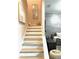 Modern staircase with wood treads, a gray accent wall, artwork, and furniture at 7675 Fordson Ln, Windermere, FL 34786