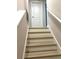Stairway leading up to a landing with a white door and railing at 7675 Fordson Ln, Windermere, FL 34786