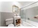 Bathroom showcasing gray tiled walls, toilet, sink, vanity, and sliding glass shower doors at 770 Manor Dr, Bartow, FL 33830