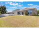 Spacious backyard with lush green grass and a patio area with comfortable seating at 902 Grand Hilltop Dr, Apopka, FL 32703